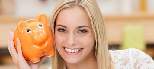 Beraterin hält oranges Sparschein neben ihr Gesicht