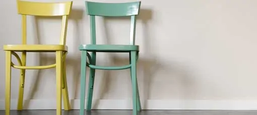 Ein gelber und ein grüner Stuhl stehen nebeneinander